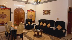 A living room with a dining area, featuring a sofa set, chairs, a coffee table, and a decorative rug. - 6 - 8 Guests 3 Bedrooms 3 Beds 4 Baths. (Karachi)