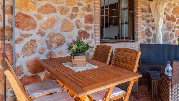 A stone wall with a window and a table with chairs. - Vacation home Salvia by Interhome (Massa Marittima)