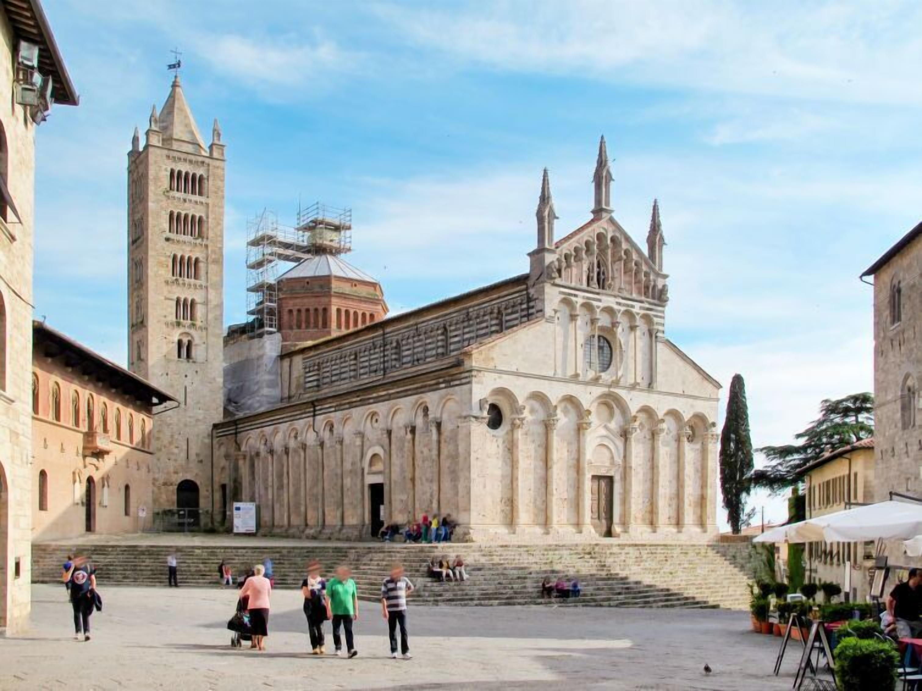 A historic building with a central dome and two towers, surrounded by a courtyard with steps leading up to it.