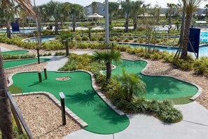 A golf course with multiple putting greens and a pool area. - Lakefront Pool & Spa | Steps to Clubhouse | Prime Storey Lake Location (Kissimmee)