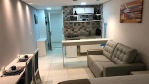 A compact living space with a kitchenette, a dining area, and a sofa. - Miramar Laguna Beach (Ipojuca)