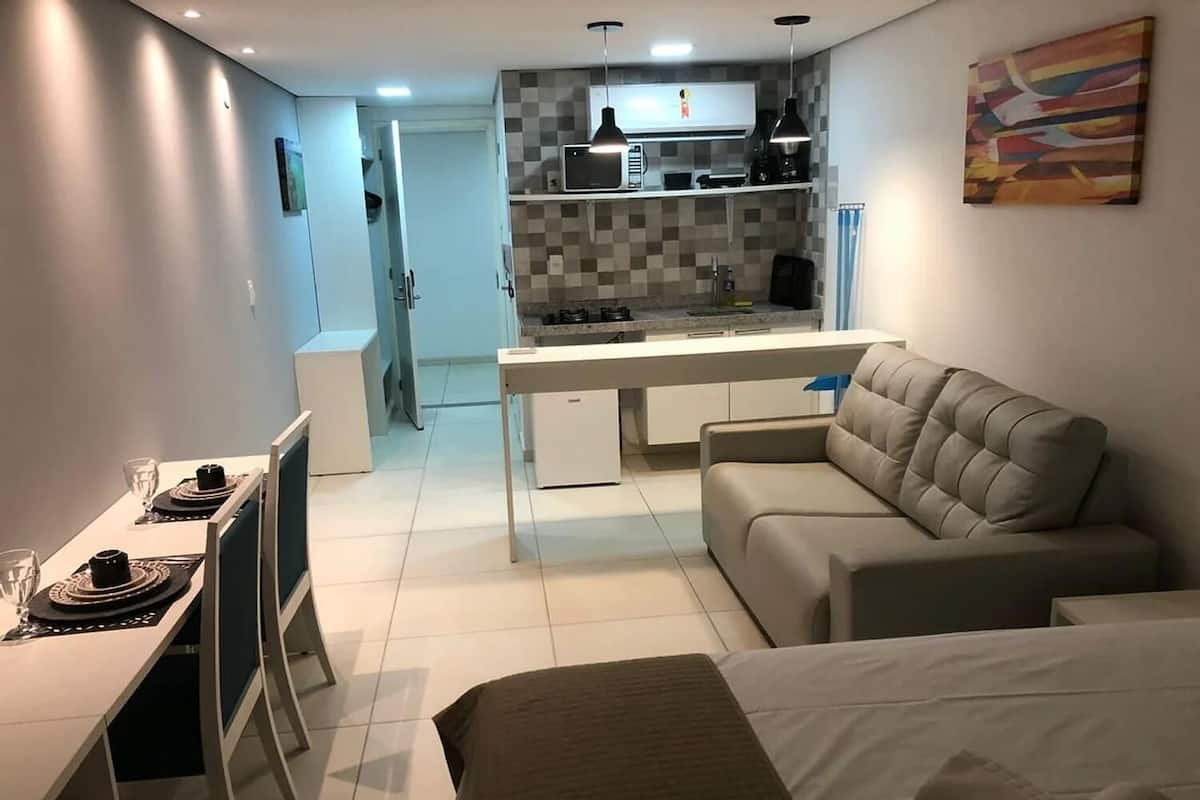 A compact living space with a kitchenette, a dining area, and a sofa.