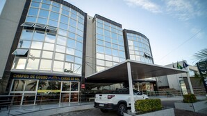 Een modern gebouw met grote glasramen en een overdekte ingang.