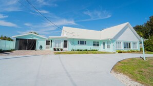Une maison à deux étages avec un garage, une allée couverte et une pelouse bien entretenue.