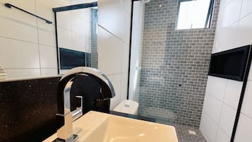 Deluxe appartement | Badkamer | Een douche, handdoeken, zeep, shampoo