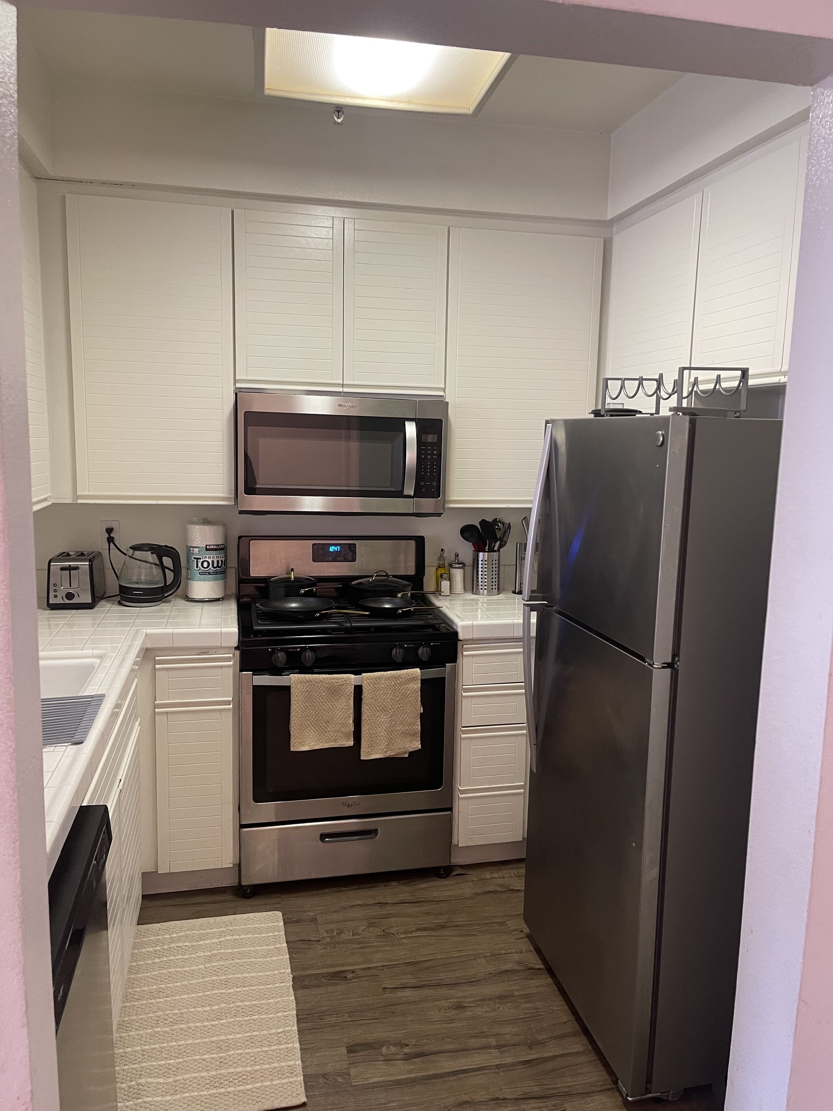 Una cocina compacta con microondas, estufa y refrigerador.