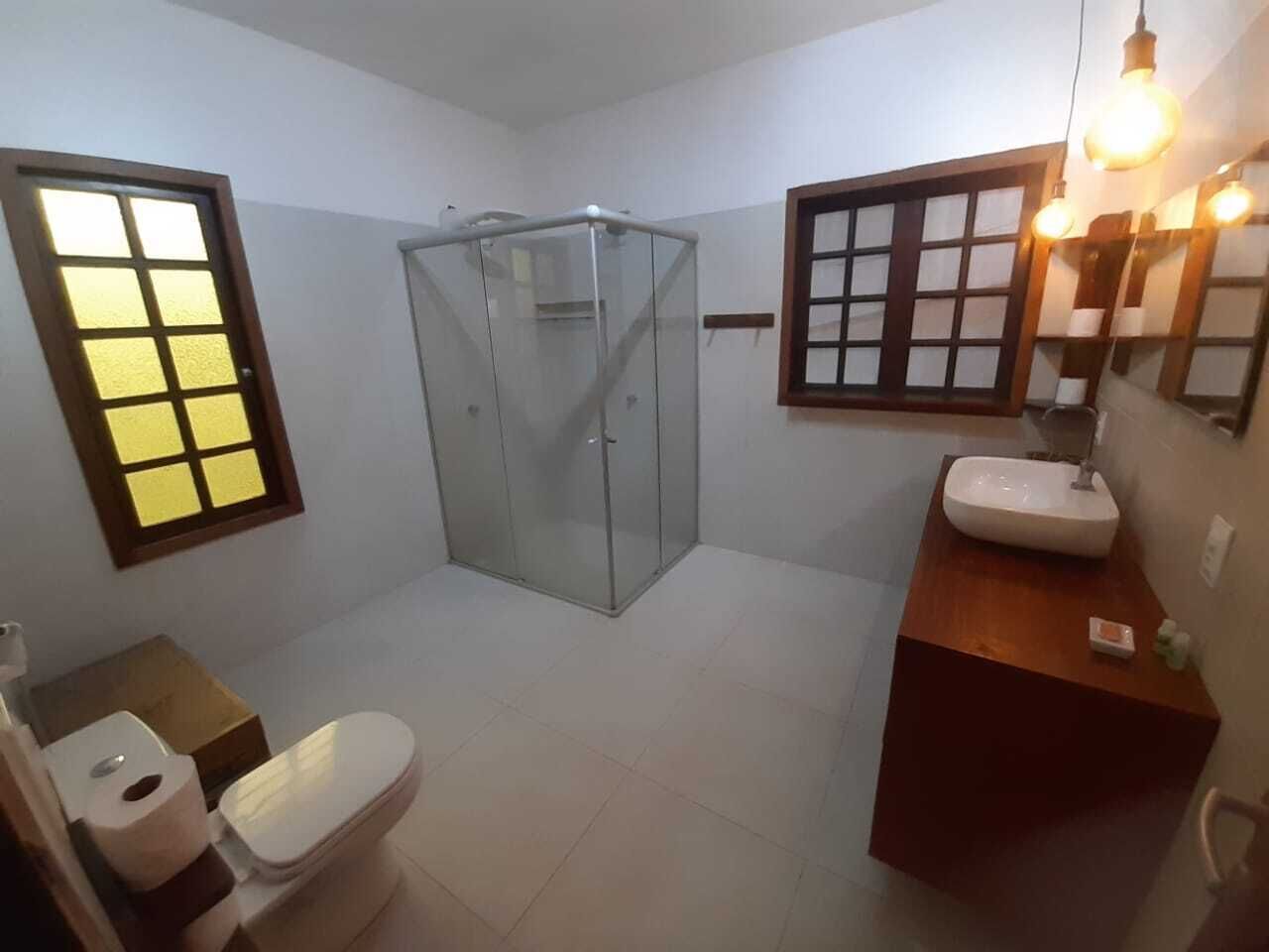 Une petite salle de bain comprenant des toilettes, une douche à parois de verre et un lavabo avec un miroir.