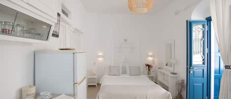 A bedroom with a bed, a nightstand, a dresser, a mirror, a window with curtains, and a door.