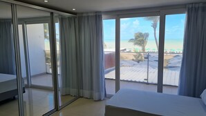 A hotel room with a balcony, a bed, and a view of the beach. - Miramar Na Praia (João Pessoa)