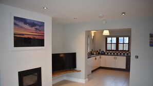 A modern kitchen with a window, a built-in TV, and a fireplace.