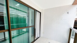 A modern bathroom with a glass partition, white tiled walls, and a visible shower area. - Miramar Luxor Paulo Miranda - C. Branco (João Pessoa)