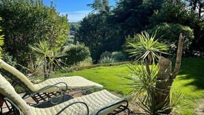 Un jardin avec un fauteuil et une petite table.
