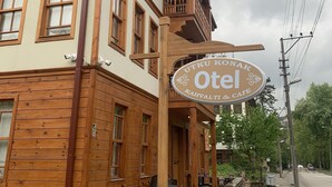 A wooden building with a sign for "Utkul Konak Otel Kahvaltı & Cafe".