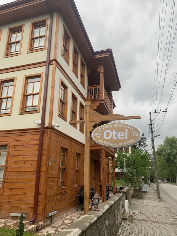 Un edificio de madera con un letrero que dice "Utkul Konak Otel Kahvaltı & Cafe".