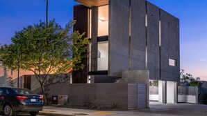 A modern two-story house with a large open window on the second floor, a tree in the front yard, and a parked car. - 4 Bed Penthouse w/City View Deck and Firepit. Near Zoo (San Diego)
