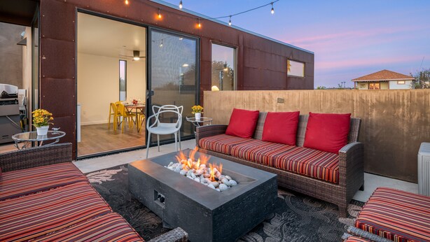 An outdoor patio with a fire pit, seating area, and string lights. - 4 Bed Penthouse w/City View Deck and Firepit. Near Zoo (San Diego)