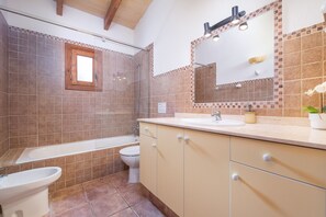 A bathroom with a bathtub, toilet, sink, and mirror. - Majorca holiday rental - Villa Joana (Pollensa / Pollença)