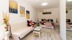 Un dormitorio moderno con un sofá, una cama con ropa de cama floral y tres cuadros en la pared.
