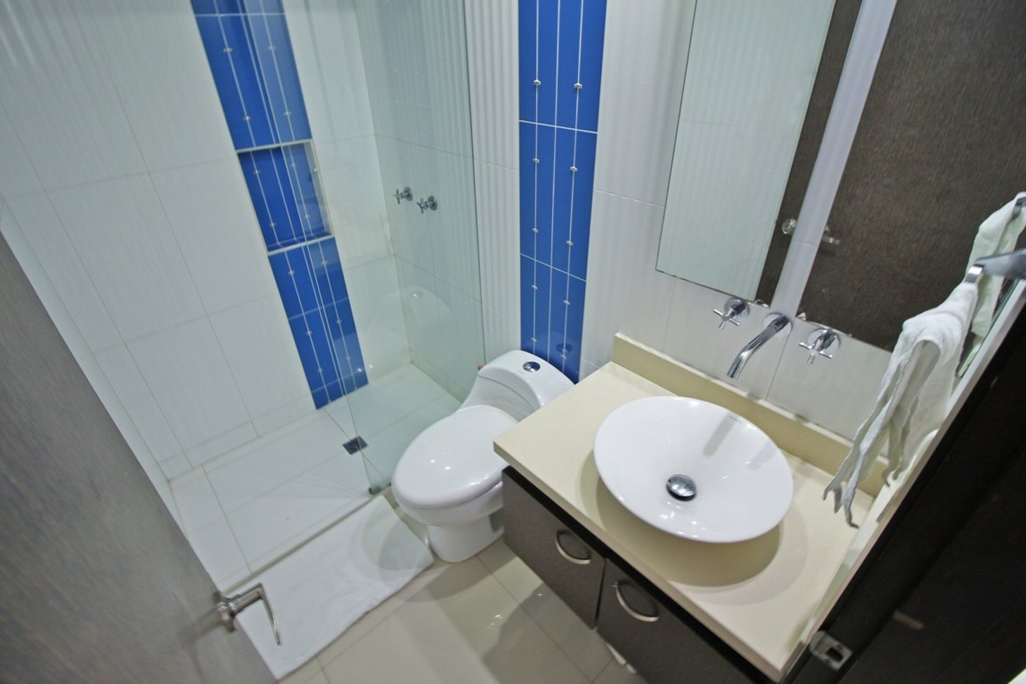 Un baño con inodoro, lavamanos y espejo.