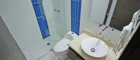 Un baño con inodoro, lavamanos y espejo.