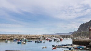 Um porto com vários barcos atracados em um cais de concreto.