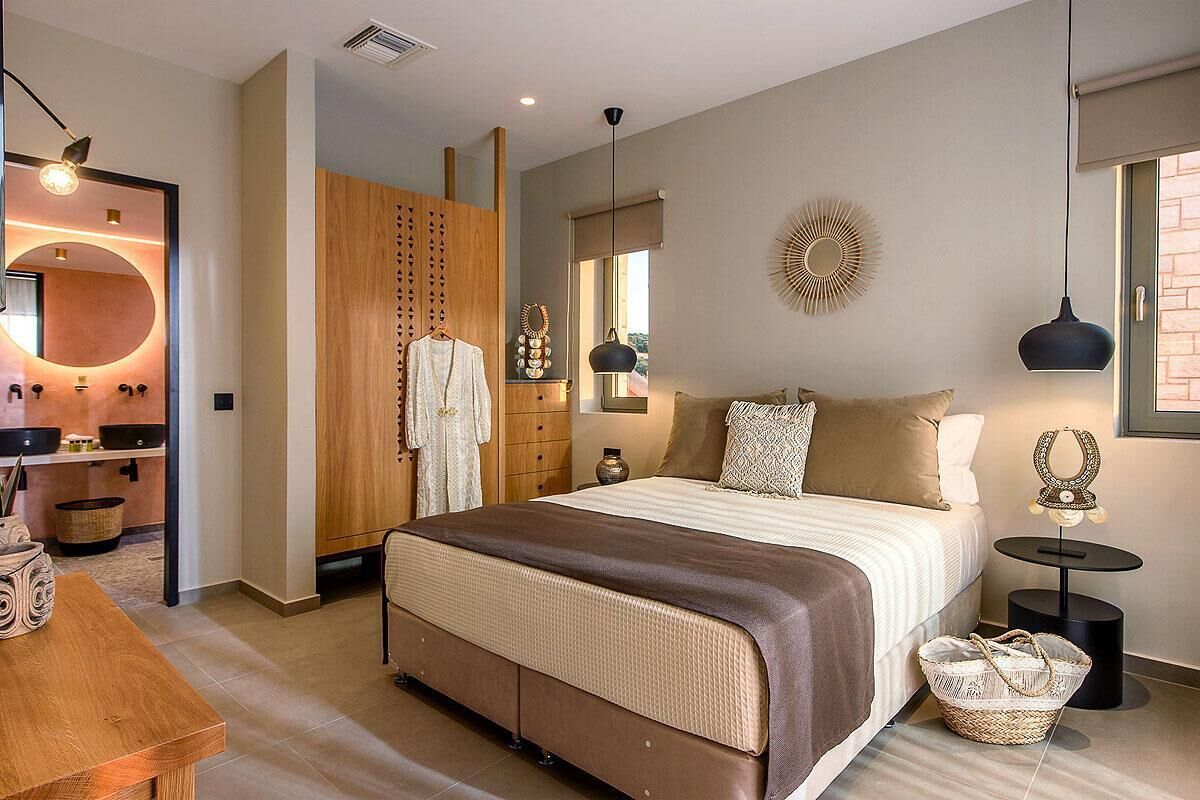 Un dormitorio moderno con una cama grande, un armario de madera y un espejo redondo.