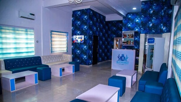 A hotel lobby with a starry wall mural, a bar area, and seating arrangements. - Blumerrit Hotel & Suites (Lagos)
