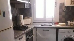 A compact kitchen with a refrigerator, microwave, oven, dishwasher, and a window providing natural light. - house E. (Hammam Sousse)