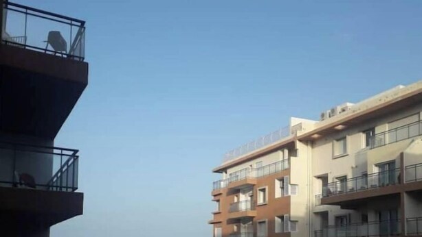 A multi-story residential building with balconies overlooking a beach. - house E. (Hammam Sousse)