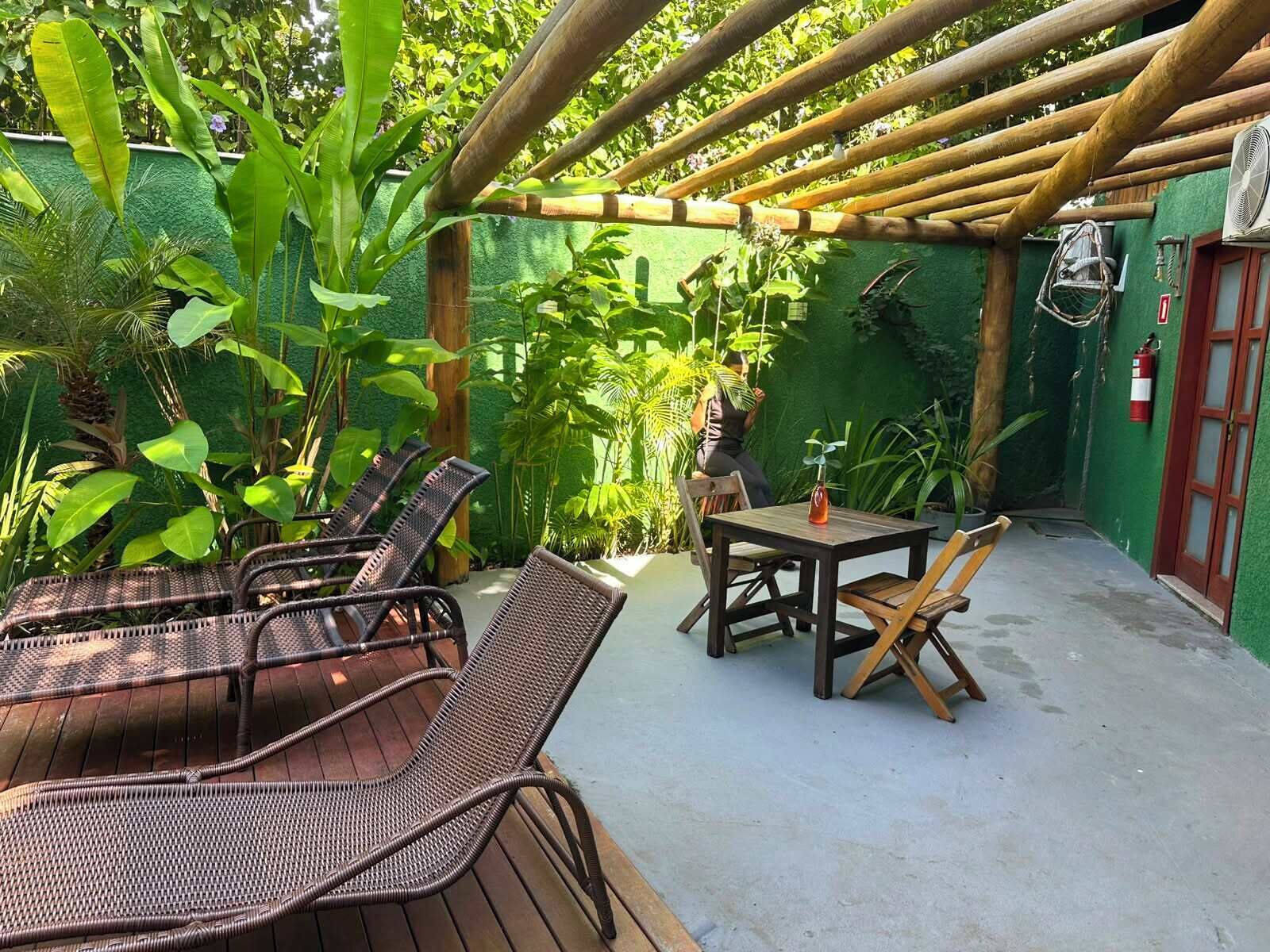 Une terrasse extérieure avec des meubles en osier, une table et une structure en forme de pergola.