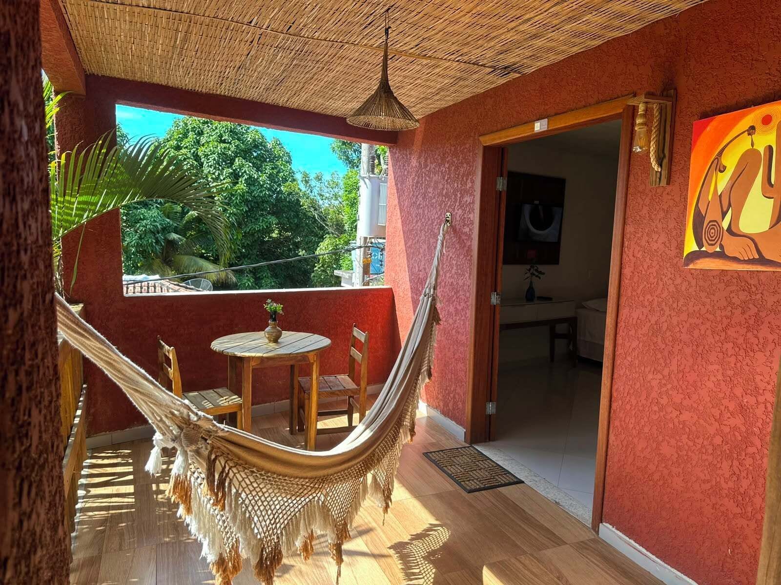A hammock chair, a small round table, and a door leading to a bathroom.