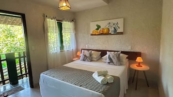 A bedroom with a bed, two bedside lamps, a painting, and a view through a window.