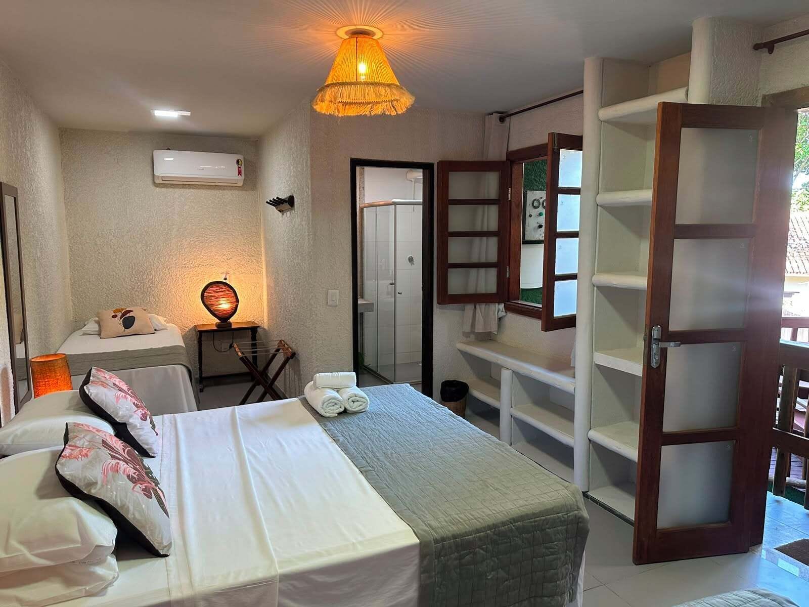 Een hotelkamer met een bed, een bureau met een lamp, een kledingkast en een badkamers deur.