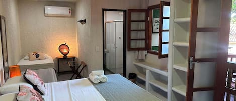 Een hotelkamer met een bed, een bureau met een lamp, een kledingkast en een badkamers deur.