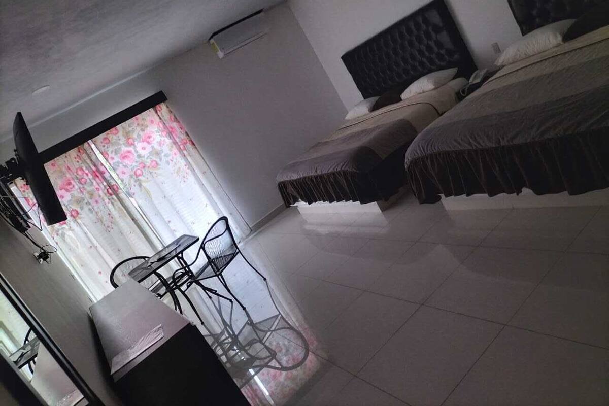 Ein Hotelzimmer mit zwei Betten, einem Schreibtisch und einem Stuhl.