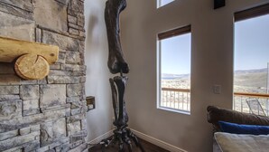 Une pièce avec un mur en pierre, une grande fenêtre et un plancher en bois.