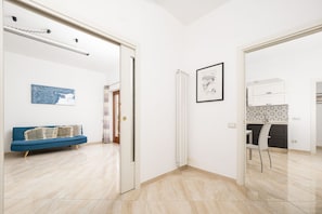 Ein modernes Wohnzimmer mit einem blauen Sofa, einem weißen Heizkörper und einem gerahmten Bild an der Wand.