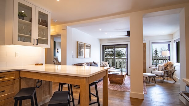 A spacious kitchen with a large island, wooden cabinets, and a view to a balcony. - Classy, contemporary, cozy, Sun Valley condo with Resort Amenities (Sun Valley)