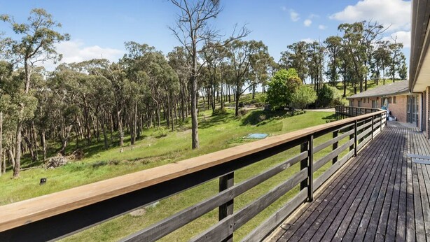 A wooden deck with a view of a grassy area and trees. - 1 bedroom studio very quiet with farm view in Heathcote junction. (Heathcote Junction)