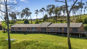 A long, single-story building with a flat roof, surrounded by a grassy area and trees. - 1 bedroom studio very quiet with farm view in Heathcote junction. (Heathcote Junction)
