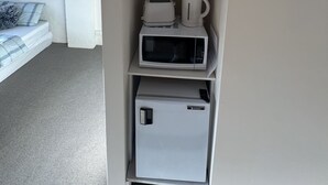 A compact kitchenette with a microwave, toaster, and coffee maker on a shelf. - 1 bedroom studio very quiet with farm view in Heathcote junction. (Heathcote Junction)