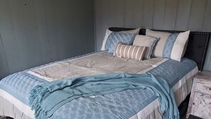Une chambre à coucher avec un lit, une table de chevet et un luminaire au plafond.