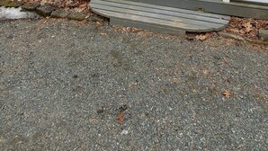 Une maison à deux étages avec un porche à l’avant, une porte et un petit garage attenant.