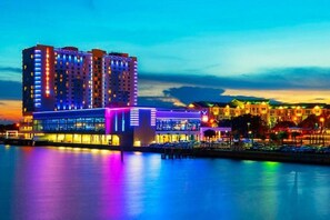 Een meerlaags hotel met een modern ontwerp, met een opvallende glazen gevel en een ligging aan het water.