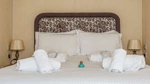 A hotel room with a large bed, two bedside lamps, and neatly folded towels. - 1 bedroom accommodation in Mullion Cove, Helston (Mullion Cove, Helston)