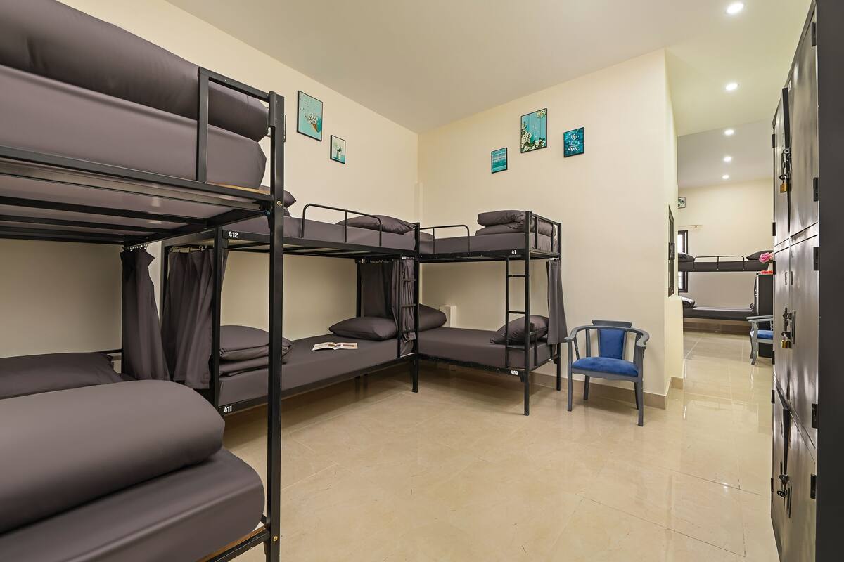 Une chambre de dortoir avec des lits superposés, une chaise et un placard.