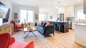 Ein modernes Apartment mit Wohnzimmer, Küche und Essbereich.