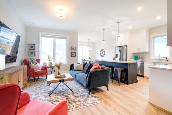 Un appartement moderne comprenant un salon, une cuisine et un coin repas.