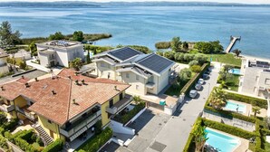 A residential area with houses, a swimming pool, and a view of a large body of water.