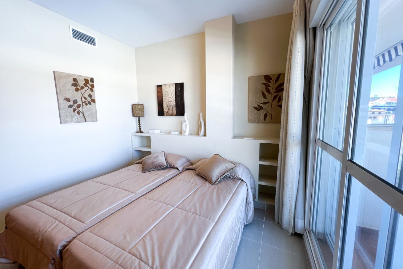 A bedroom with a bed, a nightstand, a lamp, and artwork on the walls.